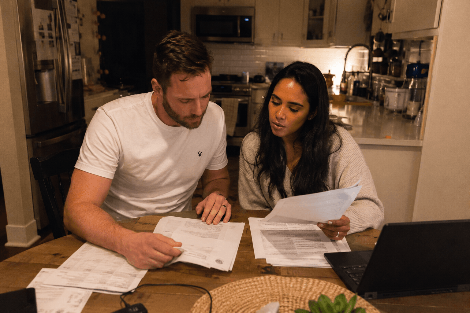 Couple reviewing medical documents at kitchen table
